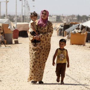 A Syrian refugee walks with her children at Zaatari refugee camp in Mafraq, Jordan, near the Syrian border, Sept. 8. Around 30,000 Syrians live at the camp, with the numbers growing each day. Mohammad Hannon/AP. 